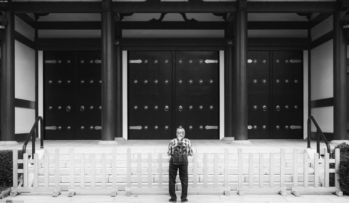 日本の寺院の大きな門の前に立つ人